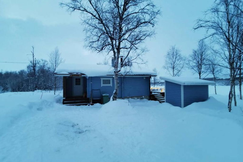 Aurora mökki kylpyaltaalla Lapissa Tenojoen rannassa, Nuorgam, Finlandia